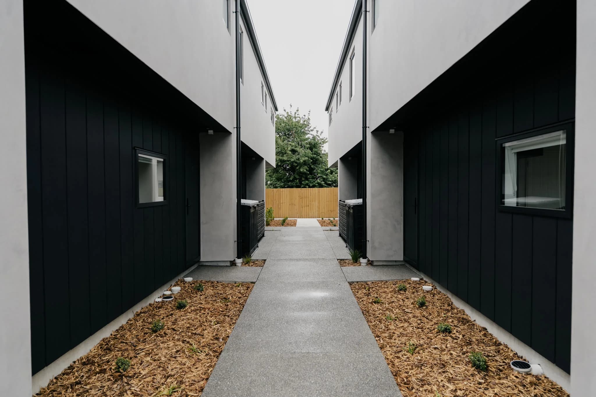 527 Hereford Street — pathway between dark-clad townhouses